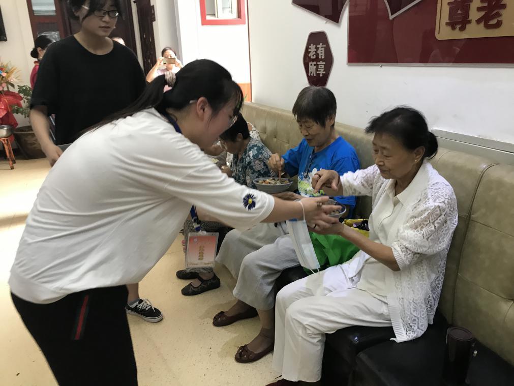 图十 社会实践队成员给老人上餐