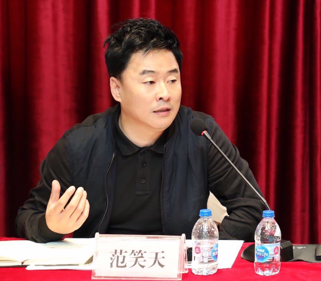 桌子前坐着穿蓝色衣服的男子 中度可信度描述已自动生成