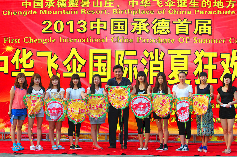 张雄舰和抛伞表演队员在承德中华飞伞狂欢夜开幕式上合影留念