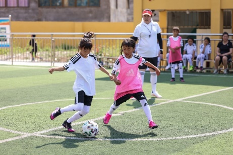 A couple of girls playing football

Description automatically generated with low confidence