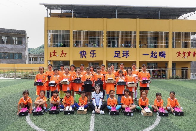 A group of kids posing for a photo in front of a yellow building

Description automatically generated with medium confidence